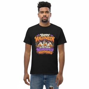 May include: A black short-sleeved t-shirt featuring a graphic with three ghosts wearing purple witch hats and sunglasses, holding orange jack-o'-lanterns. The text reads Happy Halloween To My Fellow Neurospicy Nightmares in orange and purple.