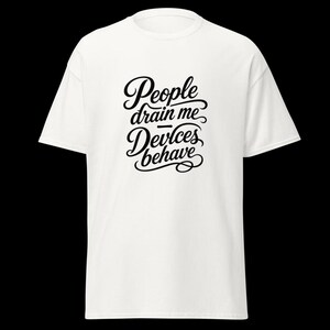 Op de afbeelding: Een wit t-shirt met korte mouwen en zwarte tekst op de borst. De tekst luidt, People drain me, Devices behave, in een gestileerd, cursief lettertype. Het t-shirt heeft een ronde hals en een standaard, recht model.