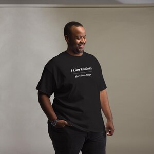 K&ouml;nnte beinhalten: Ein schwarzes kurz&auml;rmeliges T-Shirt mit wei&szlig;em Text, der I Like Routines lautet, gefolgt von einer horizontalen Linie und dem Text More Than People. Das T-Shirt hat einen Rundhalsausschnitt und eine Standardpassform f&uuml;r ein schlichtes Design.