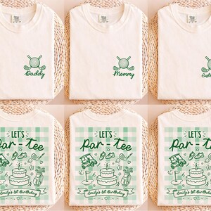 May include: A collection of six off-white t-shirts featuring green ink designs. Three shirts display a small chest graphic of crossed golf clubs and a ball with text. Three shirts feature a large green gingham print with golf icons and text.