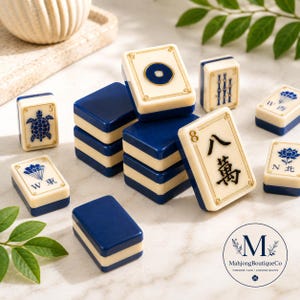 May include: A collection of rectangular Mahjong tiles featuring a two-tone design with cream-colored faces and deep blue backs. The tiles display various blue and black engraved symbols, including a turtle, a lotus, Chinese characters, and numbers.
