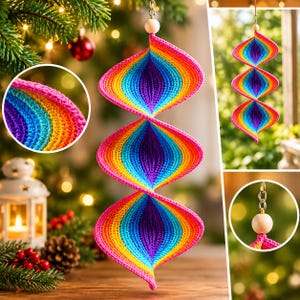 May include: A hanging spiral ornament featuring a vibrant rainbow gradient of crocheted yarn. The structure consists of three connected, twisted sections in shades of pink, orange, yellow, green, blue, and purple, topped with a wooden bead and metal ring.