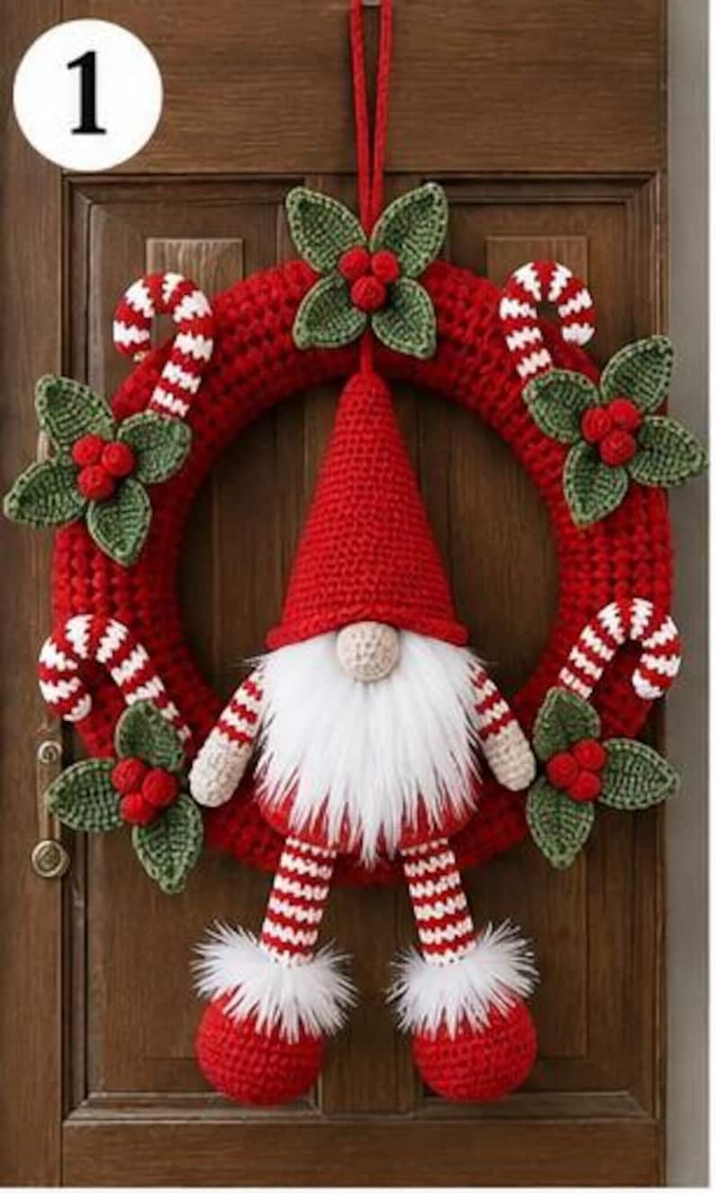 Op de afbeelding: Een gehaakte kerstkrans met een centrale kabouter met een hoge rode muts, een witte baard en gestreepte benen. De rode ronde krans is versierd met gehaakte groene hulstblaadjes, rode bessen en rood-witte zuurstokken.