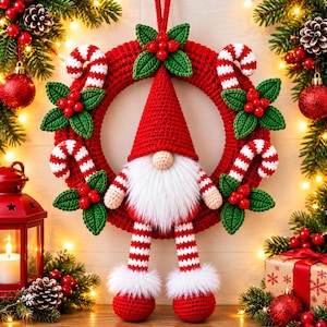 Op de afbeelding: Een gehaakte kerstkrans met een centrale kabouter met een hoge rode muts, een witte imitatiebont baard en lange gestreepte benen. De rode krans is versierd met gehaakte groene hulstblaadjes, rode bessen en rood-witte zuurstokken.