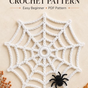 Op de afbeelding: Een wit gehaakt spinnenweb met een kleine zwarte gehaakte spin eraan vast. De tekst SPIDERWEB CROCHET PATTERN Easy Beginner PDF Pattern staat erboven. Het ontwerp heeft een centrale ring met uitstralende spaken.
