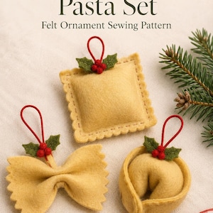 May include: Three felt pasta ornaments including a square ravioli, a bow-tie farfalle, and a tortellini, each topped with green felt holly leaves and red berries, with red hanging loops. Text reads: Dreamy Yarn Studio Nonna's Christmas Pasta Set.