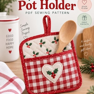 Può includere: Una presina quadrata con tasca in tessuto a quadretti rossi e bianchi, decorata con un'applicazione a forma di cuore con foglie di agrifoglio e bacche. La parte superiore è trapuntata con un motivo di agrifoglio e un cucchiaio di legno.