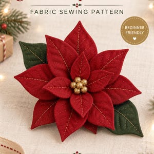 Peut inclure: Un patron de couture en tissu intitulé Christmas Poinsettia par Dreamy Yarn Studio. L'image présente une fleur de poinsettia en tissu rouge faite à la main avec des feuilles vertes et un centre en perles dorées, avec des coutures dorées visibles.