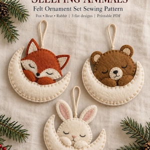 May include: A sewing pattern for felt ornaments titled Winter Woodland Sleeping Animals. The set includes three flat designs of a fox, bear, and rabbit, each sleeping on a cream-coloured crescent moon with a hanging loop. The text reads: Winter Woodland Sleeping Animals, Felt Ornament Set Sewing Pattern, Fox, Bear, Rabbit, 3 flat designs, Printable PDF.
