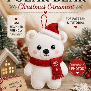 Peut inclure: Une décoration de Noël en feutrine représentant un ours polaire blanc portant un bonnet de Père Noël rouge et une écharpe rouge brodée de flocons blancs. L'ours a des yeux et un nez noirs et des joues roses. Texte : FELT PATTERN POLAR BEAR.