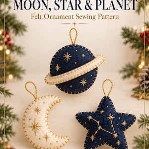 May include: A sewing pattern titled CHRISTMAS MOON, STAR & PLANET featuring three felt ornaments: a navy planet with a cream ring, a cream crescent moon, and a navy star. Each ornament has gold embroidery and a gold hanging loop.