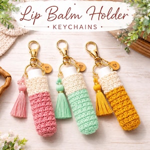 Peut inclure: Trois porte-baumes à lèvres avec des anneaux dorés et de petites breloques en forme de cœur. Chaque étui est en crochet rose, vert menthe ou jaune, surmonté d'une section crème et d'un pompon assorti. Le texte indique Lip Balm Holder KEYCHAINS.