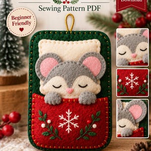 Peut inclure: Un patron de couture PDF pour ornement de souris en feutrine, présentant une base rectangulaire vert foncé avec une poche rouge. La poche affiche un flocon blanc et des brins verts. Une souris grise aux oreilles roses dort à l'intérieur.