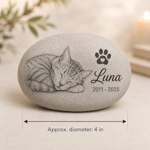 May include: A light gray oval stone memorial featuring an engraved sleeping tabby cat, a paw print with a heart, and the text Luna 2011-2025. The stone has an approximate diameter of 4 inches as indicated by the measurement graphic.