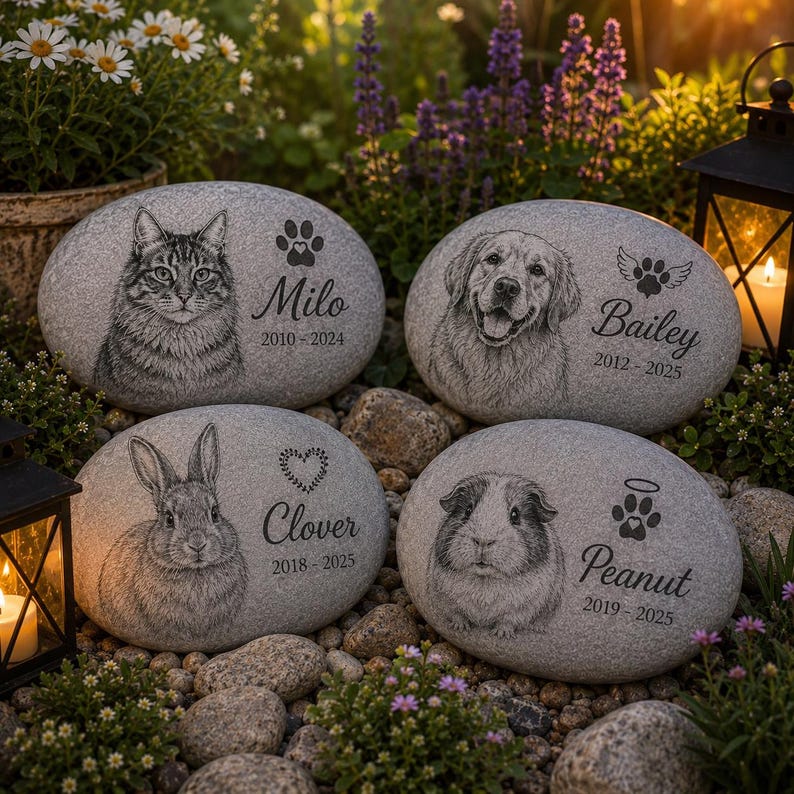 May include: Four oval gray memorial stones featuring engraved portraits of a cat, dog, rabbit, and guinea pig. Each stone displays a name, birth and death years, and a small icon such as a paw print, heart, or halo, serving as pet grave markers.