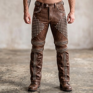 May include: Brown leather trousers featuring silver-toned metal pyramid studs arranged in geometric patterns across the thighs, knees, and lower legs. The trousers include a standard waistband with belt loops, a front button closure, and matching brown boots.