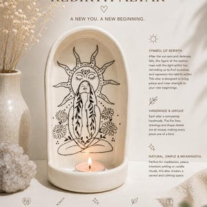 May include: An arched, off-white ceramic altar featuring a black line drawing of a person sitting in a meditative pose beneath a sun. A small, lit tea light candle sits at the base. The text reads REBIRTH ALTAR, A NEW YOU. A NEW BEGINNING.