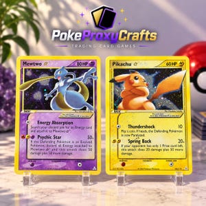 May include: Two rectangular trading cards displayed on clear plastic stands. The left card is purple, featuring Mewtwo with 80 HP and attacks Energy Absorption and Psychic Star. The right card is yellow, featuring Pikachu with 60 HP and attacks Thundershock and Spring Back.
