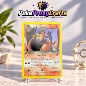 Könnte beinhalten: Eine Dark Charizard Sammelkarte mit gelbem Rand, die einen feuerspeienden Drachen zeigt. Die Karte enthält den Text Dark Charizard, 80 HP, Nail Flick und Continuous Fireball, sowie ein Flammensymbol und einen 1st Edition Stempel.