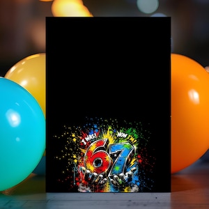 May include: A black rectangular greeting card featuring a colorful graphic at the bottom. The graphic displays the text I WAS! and NOW I'M! surrounding the number 67, which is rendered in a vibrant, paint-splattered style held by two hands.