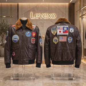 Puede incluir: Una chaqueta de aviador de cuero marrón oscuro con cuello de piel sintética marrón, cremallera frontal, puños acanalados y numerosos parches bordados coloridos. La espalda muestra un parche grande con el texto FAR EAST CRUISE 63-4 USS GALVESTON.