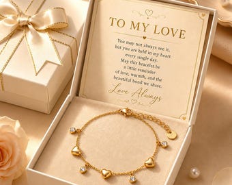 Könnte beinhalten: Ein goldfarbenes Kettenarmband mit abwechselnden Herzanhängern und kleinen klaren Kristallen, präsentiert in einer offenen weißen Geschenkbox. Die Innenseite des Deckels zeigt den Text TO MY LOVE und eine liebevolle Botschaft.