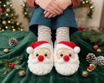 Puede incluir: Un par de zapatillas de ganchillo con forma de caras de Papá Noel, que presentan barbas blancas, gorros rojos con pompones blancos, mejillas rosadas y narices rojas. Las zapatillas se llevan sobre calcetines de punto claros.
