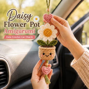 Puede incluir: Un adorno de coche amigurumi de ganchillo con forma de maceta de margarita, que incluye una flor blanca con centro amarillo, hojas verdes y una maceta color canela con cara sonriente. Incluye dos corazones rosas, cuentas de madera y borla.