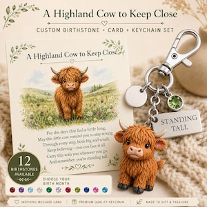 May include: A Highland cow keychain with a silver lobster clasp, a round blank charm, a green birthstone charm, and a rectangular tag engraved with the text STANDING TALL, accompanied by a matching message card featuring a Highland cow illustration.