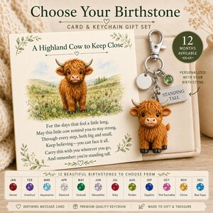 May include: A gift set featuring a card with a Highland cow illustration and the text A Highland Cow to Keep Close, paired with a metal keychain featuring a miniature Highland cow figurine, a silver disc, a green crystal, and a tag reading STANDING TALL.