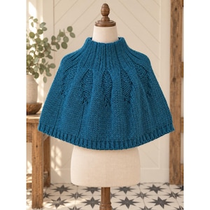 May include: A teal blue knitted poncho featuring a high mock neck collar, a ribbed hem, and a repeating vertical leaf-like cable knit pattern across the chest and shoulders. The garment is displayed on a mannequin torso with a flared silhouette.