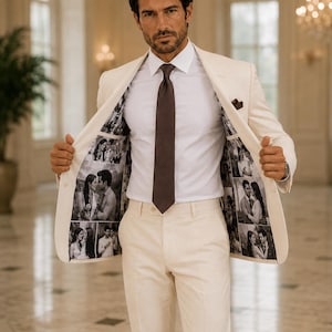Puede incluir: Un traje de color crema compuesto por una americana y pantalones, combinado con una camisa blanca de cuello rígido y una corbata marrón oscuro. El forro interior de la americana presenta un collage de fotos en blanco y negro de parejas.