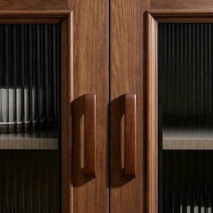 Peut inclure: Une armoire en bois brun fonc&eacute; dot&eacute;e de deux portes avec des panneaux en verre cannel&eacute; vertical. Chaque porte poss&egrave;de une poign&eacute;e en bois massif assortie. &Agrave; l'int&eacute;rieur, des &eacute;tag&egrave;res claires contiennent des rang&eacute;es de livres blancs.