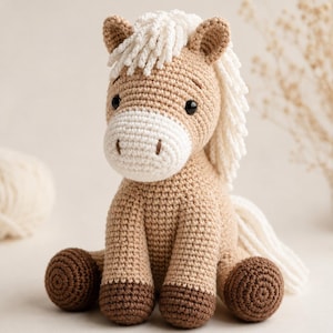 Peut inclure: Un jouet cheval au crochet avec un corps beige clair, un museau blanc et une crinière blanche. Le cheval a des sabots marron foncé, des yeux en perles noires et un nez brodé. Le jouet est réalisé avec des mailles visibles et est assis.