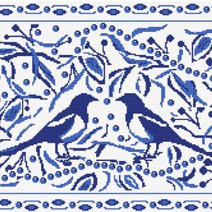 May include: A rectangular cross-stitch pattern featuring two birds facing each other, surrounded by intricate botanical motifs of leaves, berries, and branches in shades of blue on a white background, enclosed by a decorative blue and white border.