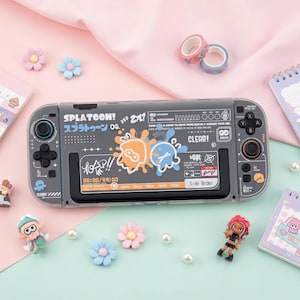 May include: A gray handheld gaming console skin featuring Splatoon graphics with orange and blue ink splats, Japanese text, and various icons. The design includes the word SPLATOON!, the text CLEAR!, and a digital timer display reading 00:00/24:00.