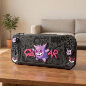 Puede incluir: Una funda negra para consola de juegos portátil con un personaje Gengar morado pixelado y el texto rosa GENGAR. La superficie está decorada con varias ilustraciones oscuras de fantasmas, incluyendo un gráfico de Haunter y dos tapas de joystick de Gengar.
