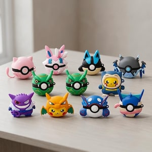 Puede incluir: Una colección de once fundas protectoras de silicona para auriculares inalámbricos, cada una con un diseño de personaje único inspirado en varias criaturas, incluyendo figuras esféricas con botones centrales y detalles faciales.
