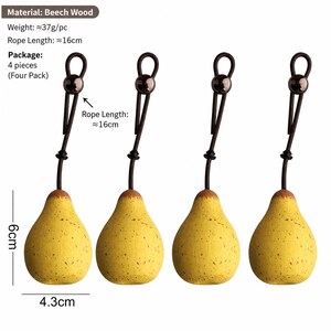 Może przedstawiać: Cztery ozdoby w kształcie gruszki wykonane z drewna bukowego, każda o wysokości 6 cm i szerokości 4,3 cm. Każdy element posiada ciemnobrązowy sznurek z przesuwanym koralikiem, długość sznurka 16 cm i wagę około 37 gram&oacute;w na sztukę.