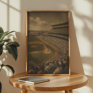 Könnte beinhalten: Ein gerahmter vertikaler Kunstdruck mit einer sepiafarbenen Hochwinkelaufnahme eines überfüllten Baseballstadions. Das Bild zeigt das weitläufige grüne Spielfeld, das Infield aus Erde und die mit Zuschauern gefüllten Tribünen unter einem bewölkten Himmel.