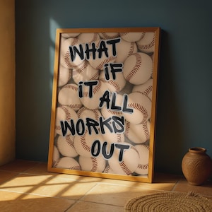 May include: A framed wall art print featuring a background of white baseballs with red stitching. The text "WHAT IF IT ALL WORKS OUT" is printed in bold black letters across the centre of the baseballs, contained within a light wood frame.