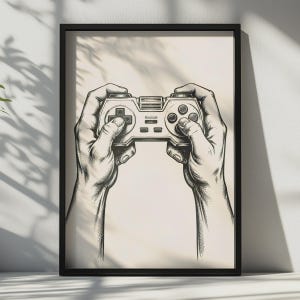 May include: A black and white line art illustration framed in black, depicting two hands holding a retro-style video game controller. The controller features a directional pad on the left, four circular action buttons on the right, and central buttons.