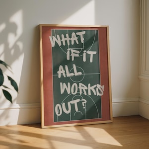 May include: A rectangular framed wall art print featuring a dark green basketball court diagram with white court lines. The white text overlay reads, WHAT IF IT ALL WORKS OUT? The frame is light wood, and the border surrounding the court is red.