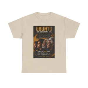 May include: A beige short-sleeve t-shirt featuring a rectangular graphic print. The design displays the text UBUNTU I AM BECAUSE WE ARE, a descriptive paragraph, and a portrait of four individuals, with the quote Learn to Love each other harder than we were taught not to at the bottom.