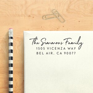 May include: A white envelope with a black return address label that reads "The Simmons Family, 1505 Vicenza Way, Bel Air, CA 90077".