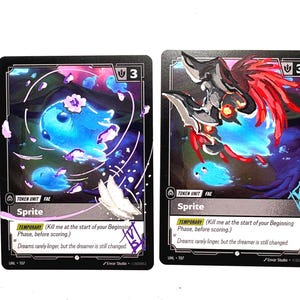 Può includere: Due carte collezionabili rettangolari etichettate Sprite, che mostrano una creatura blu luminosa e petali di fiori rosa a sinistra, e una figura scura corazzata con accenti rossi a destra. Entrambe le carte includono il testo Token Unit Fae e Temporary.