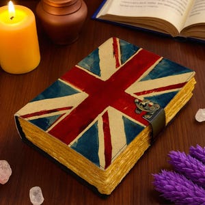 May include: A rectangular journal featuring a printed Union Jack flag design on the cover. The book includes a dark metal latch closure and thick, textured, light brown pages with deckled edges visible along the side of the closed book.