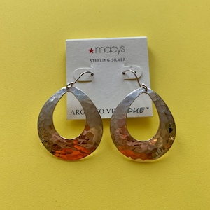 May include: A pair of sterling silver teardrop earrings with a hammered texture. The earrings are displayed on a white card with the Macy's logo and the words "STERLING SILVER". The background is a solid yellow.