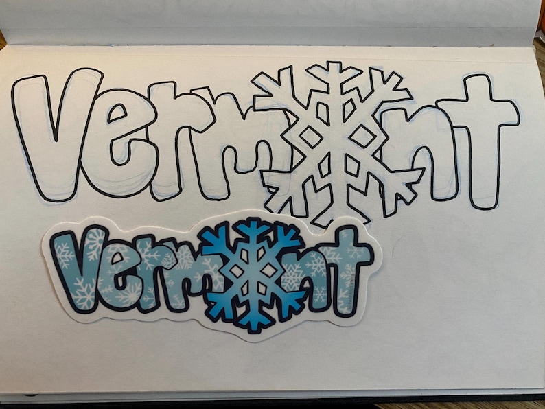 May include: A blue and white sticker with the word "Vermont" in bold, black letters. The sticker has a snowflake pattern and a large blue snowflake in the center.