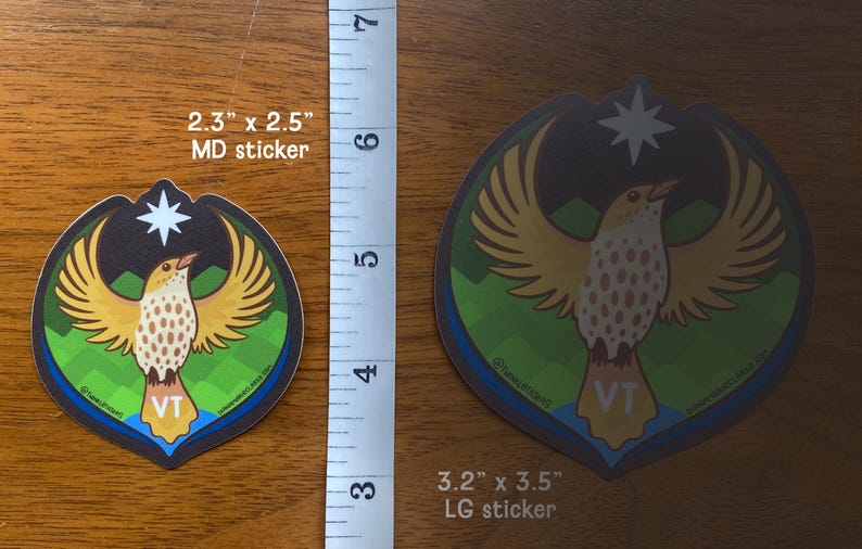 Puede incluir: Dos pegatinas con un dise&ntilde;o de p&aacute;jaro con alas extendidas, una estrella y las letras "VT". La pegatina m&aacute;s grande mide 8,1 cm x 8,9 cm, la m&aacute;s peque&ntilde;a 5,8 cm x 6,4 cm. El p&aacute;jaro tiene alas amarillas y un cuerpo moteado.